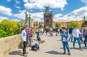 Prag, Tjeckien, 13 maj 2019 människor går nerför den kullerstensbelagda fotgängaren Charles Bridge foto