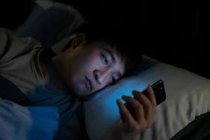 ung asiatisk man använder smartphone på natten foto