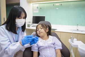 kvinnlig tandläkare visar invisalign till en liten flicka på tandklinik, tandkontroll och friska tänder koncept foto