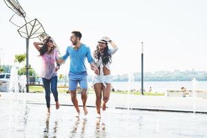 grupp vänner som har kul bredvid den offentliga fontänen på sommardagen foto