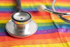 svart stetoskop på regnbågsflagga bakgrund, symbol för lgbt pride månad fira årliga i juni social, symbol för homosexuella, lesbiska, bisexuella, transpersoner, mänskliga rättigheter och fred. foto