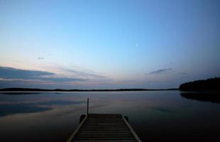 båtbrygga vid småfisksjön i natursköna saskatchewan foto