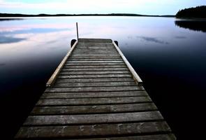 båtbrygga vid småfisksjön i natursköna saskatchewan foto