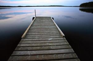 båtbrygga vid småfisksjön i natursköna saskatchewan foto