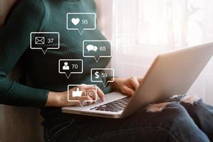 sociala medier och marknadsföring virtuella ikoner skärm concept.close up av affärskvinna att skriva tangentbord med laptop foto
