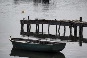 roddbåt ovanför lugnt vatten, reflektion i vatten, tyst hamn foto