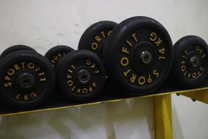 redaktionell bild av svarta hantlar på ett ställ för att träna på ett gym foto
