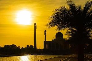 Songkhla central moské i dag till natt med färgglada himlar vid solnedgången och ljusen från moskén och reflektioner i vattnet i landmärke landskapskoncept foto