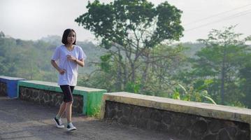 ung asiatisk kvinna glad på en jogging foto