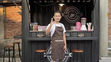 Asiatisk barista gestikulerande okej i kafé med containertema foto