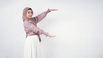 asiatisk hijab kvinna visar tom i sidled isolerad på vit bakgrund foto