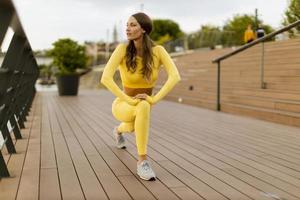 ung kvinna med stretching övning på riverside piren foto