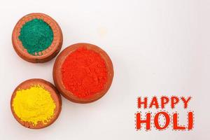 indiska festival holi koncept multi färg skål med färgglad bakgrund och skriva glad holi foto