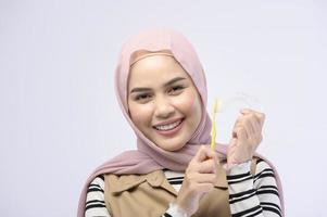 en ung muslimsk kvinna som använder tandborste med vackra tänder, tandvårdskoncept foto