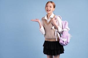 ung asiatisk high school flicka på blå bakgrund foto