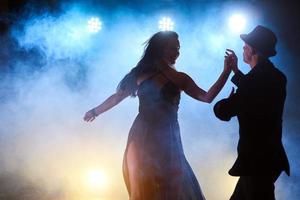 skickliga dansare som uppträder i det mörka rummet under konsertens ljus och rök. sensuellt par som utför en konstnärlig och känslomässig samtida dans foto