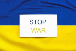 Ukrainas nationella flagga bakgrund med vitt papper med texten stop war foto