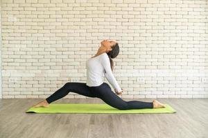 latinsk kvinna utövar yoga på mattan foto