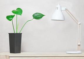 ren arbetsplats med lampa i skandinavisk stil och monstera-växt. träskrivbord minimal design. kopieringsutrymme foto