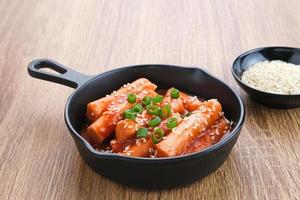 tteokbokki eller topokki , wokad riskakepinne, populär koreansk gatumat med kryddig gochujang-sås och sesamfrö. foto