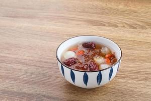 kinesiska köket, en skål med persikogummi. persikogummi är traditionell kinesisk dryck som innehåller persikogummi, fågelbo, röda dadlar, snösvamp, gojibär och stensocker. foto
