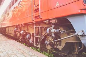 röda gamla passagerartåget nedre delar.tågmekanik.litauens järnvägsindustri. foto