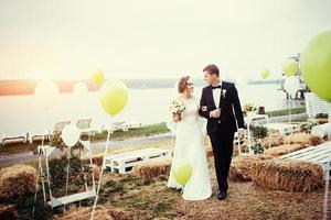 vackra unga bröllopsparet kysser, blond brud med flowe foto