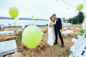 vackra unga bröllopsparet kysser, blond brud med flowe foto