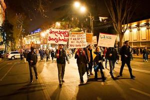 tbilisi, georgien, 2022 - grupp unga demonstranter marscherar på gatan foto