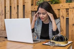 utmattad kvinna som arbetar på laptop i café foto