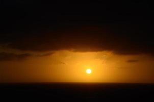 ljus solnedgång och mörk horisont foto