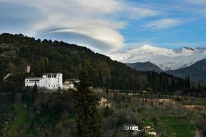 alhambra och snöande berg i Sierra Nevada under ett linsformigt moln foto