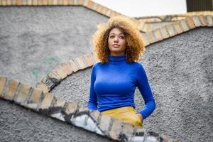 ung flicka med afro frisyr i urban bakgrund foto