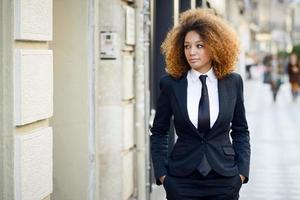 svart affärskvinna klädd i kostym och slips i urban bakgrund foto