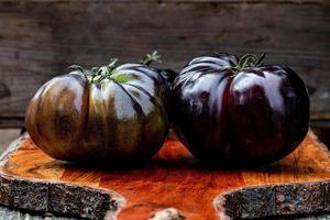 svarta heirloom tomater på skärbräda foto