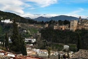 alhambra och snöande berg i Sierra Nevada under ett linsformigt moln foto