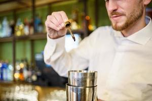 barman lägger bitter till cocktail i en modern pub foto