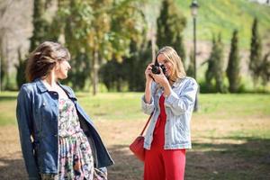 två unga turistkvinnor som fotograferar utomhus foto