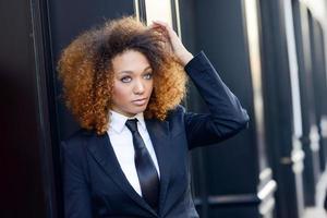 svart affärskvinna klädd i kostym och slips i urban bakgrund foto