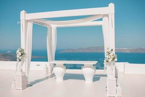 vackert bröllopstält på ön santorini. bröllopsdekorationer med rosor på bakgrund av havet, grekland, santorini. romantiskt resmål bröllop, romantik koncept foto