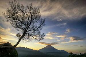 panoramisk soluppgång på bergen som ligger vid utsiktspunkten tieng, wonosobo regency, indonesien. foto