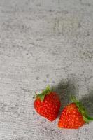mogna jordgubbar med löv på cementplattor foto