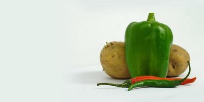 färska grönsaker paprika chili och potatis på vit bakgrund foto