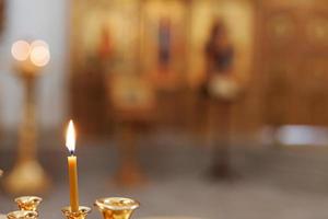 ortodox kyrka. kristendomen. festlig inredning med brinnande ljus och ikon i traditionell ortodox kyrka på påskafton eller jul. religion tro ber symbol. foto