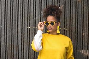 trendig svart kvinna i gula solglasögon foto
