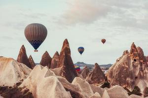 varmluftsballong som flyger över klipplandskap på cappadocia Turkiet. foto