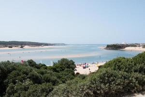 familjens sommarlov. utsikt över stranden med människor i fjärran vid vila nova de milfontes. foto