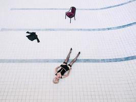 ung kvinna i svarta underkläder och strumpor ensam i den tomma poolen foto