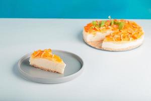 närbild detaljvy skivad orange cheesecake eller pudding, dekorerad med mogen orange frukt. foto