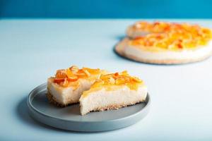 närbild detaljvy skivad orange cheesecake eller pudding, dekorerad med mogen orange frukt. foto